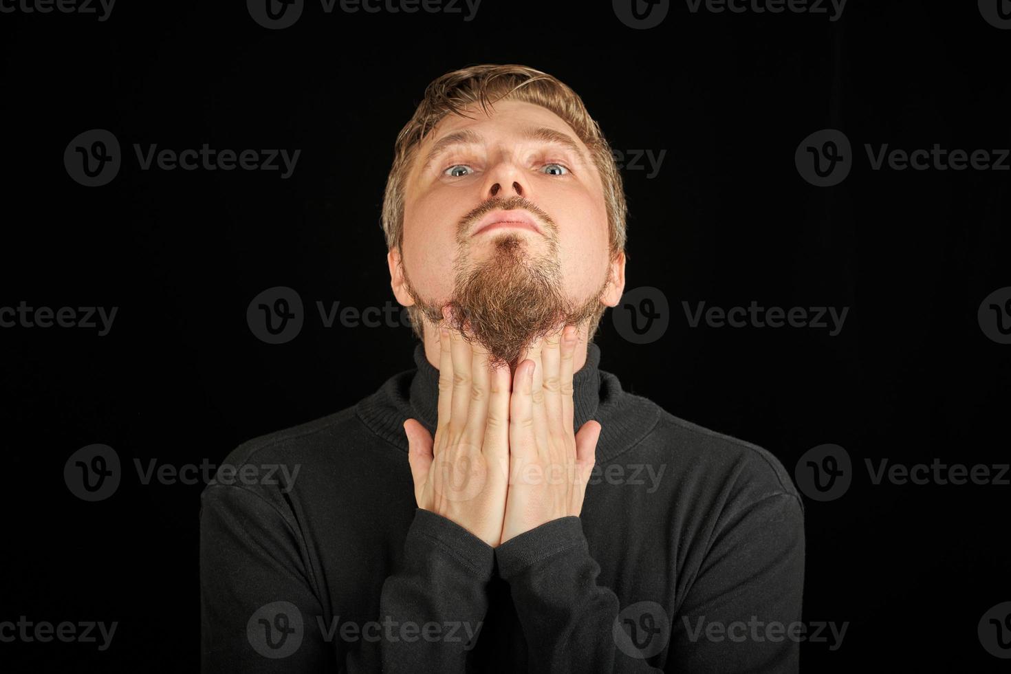 Cute bearded man, threw head back, black background photo