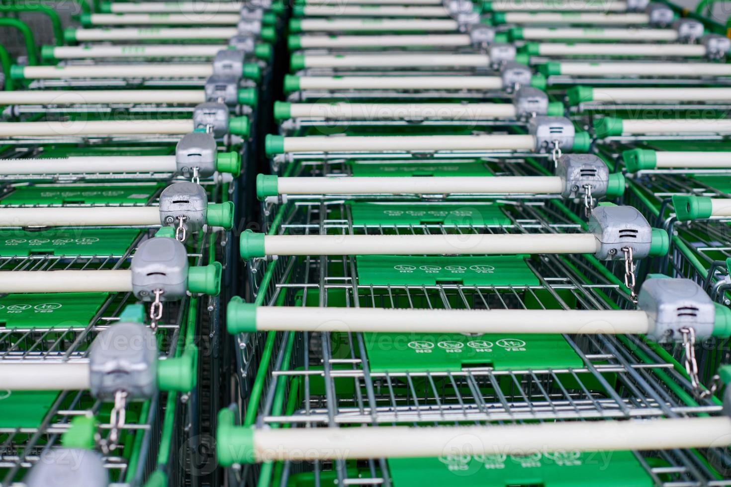 Row of parked trolleys or shopping carts in supermarket photo