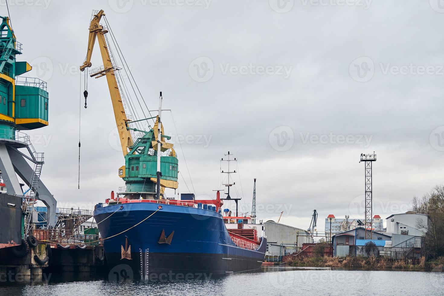 Harbor cranes and moored ship in port photo