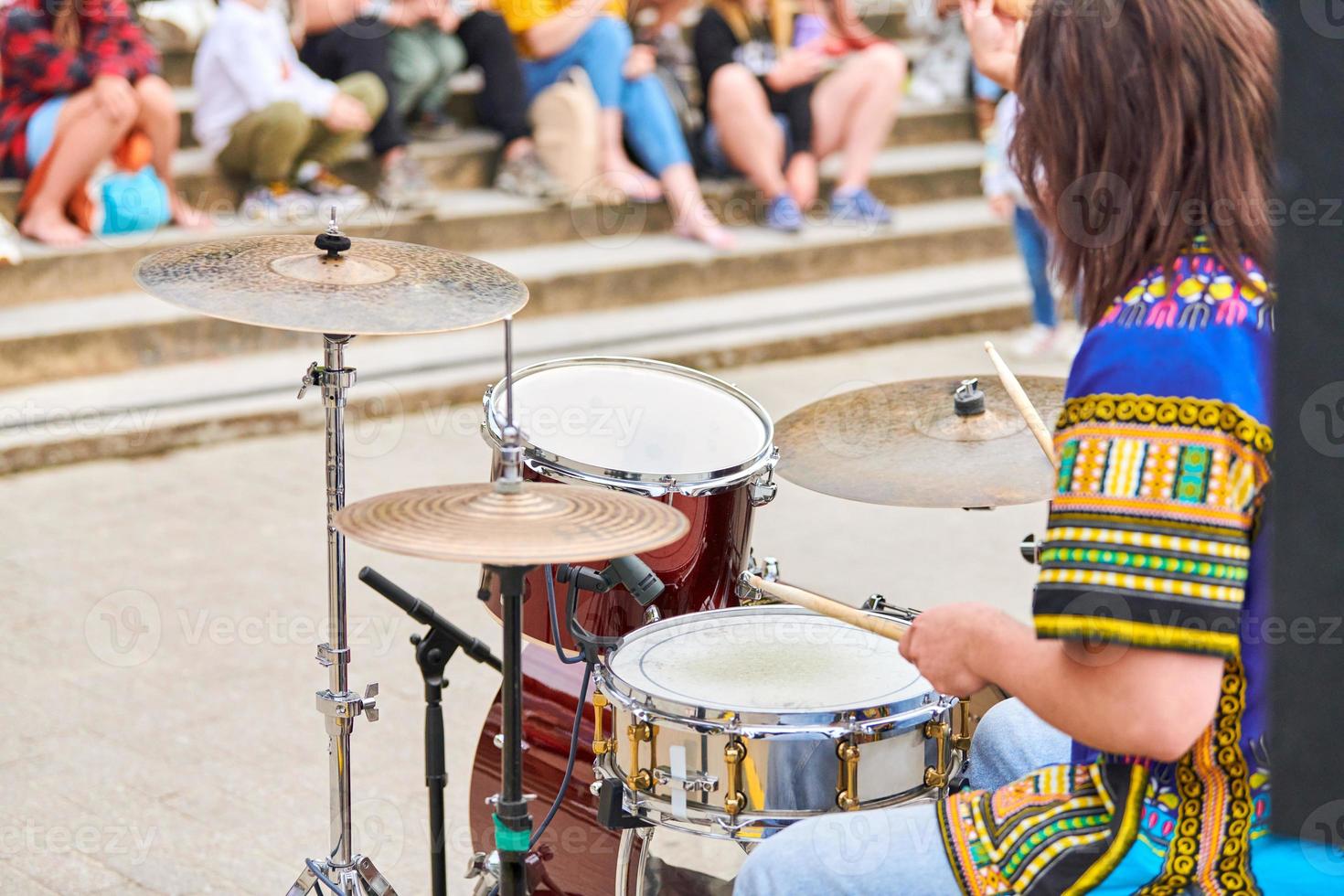 Drummer man playing drums percussion with drum sticks, drum set on concert stage, sticks and drums photo