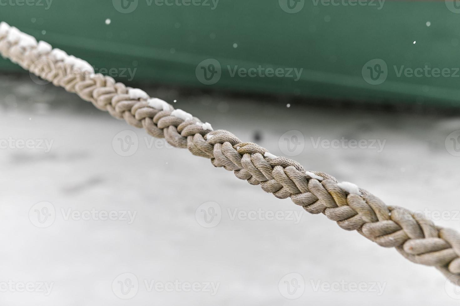 Rope tied ship on background of green ship side, close up photo