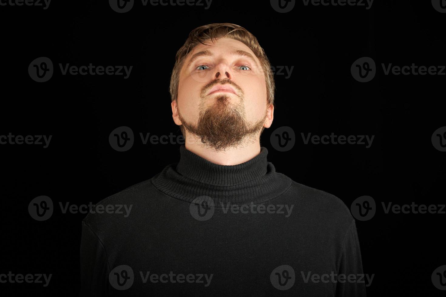 Cute bearded man, threw head back, black background photo