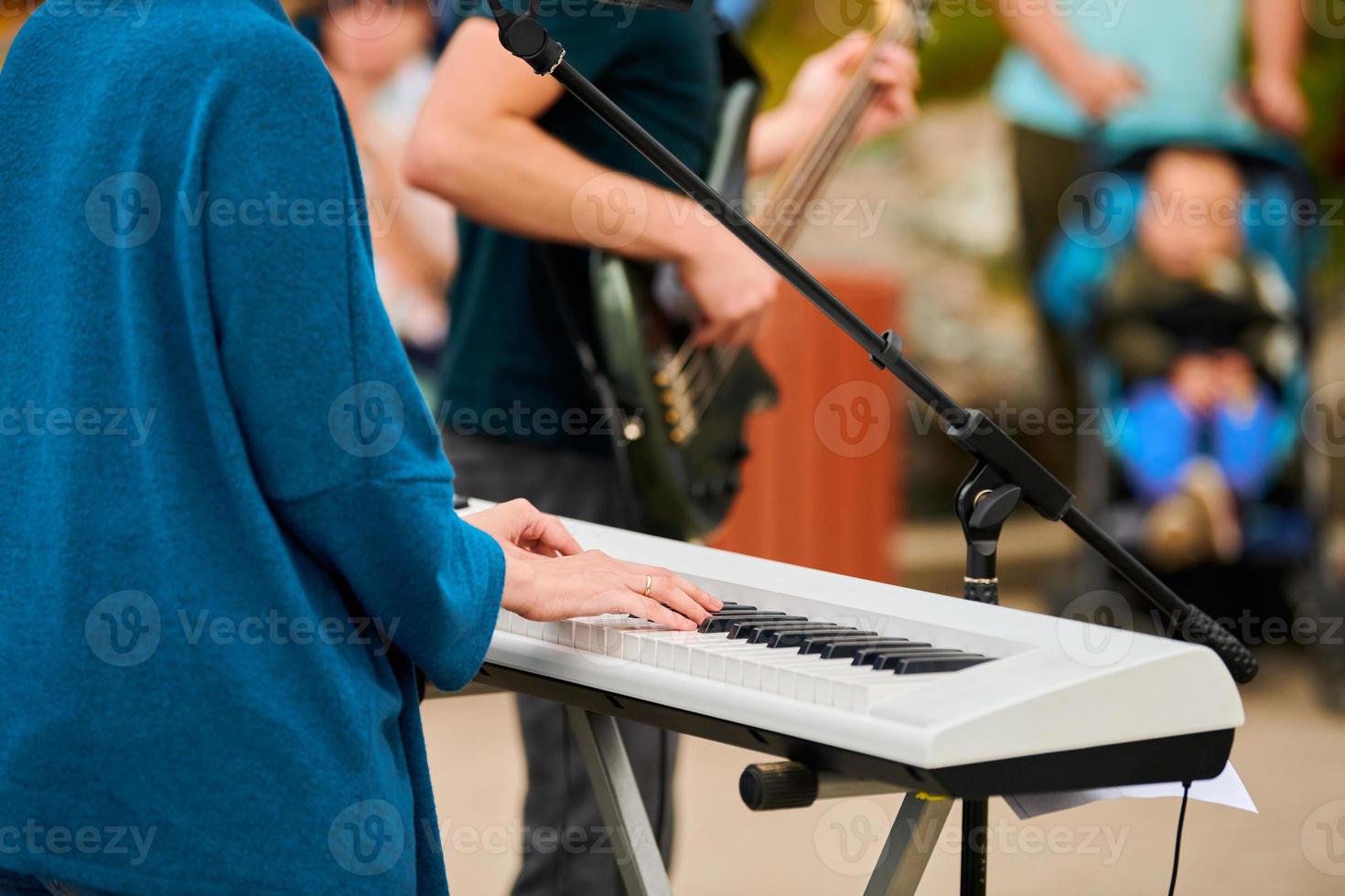 Musician woman playing on synthesizer keyboard piano, hands press synthesizer keys on concert stage photo