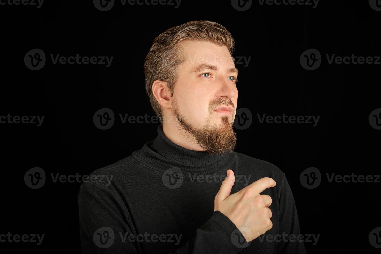 hombre barbudo pensativo, retrato de medio perfil, fondo negro foto