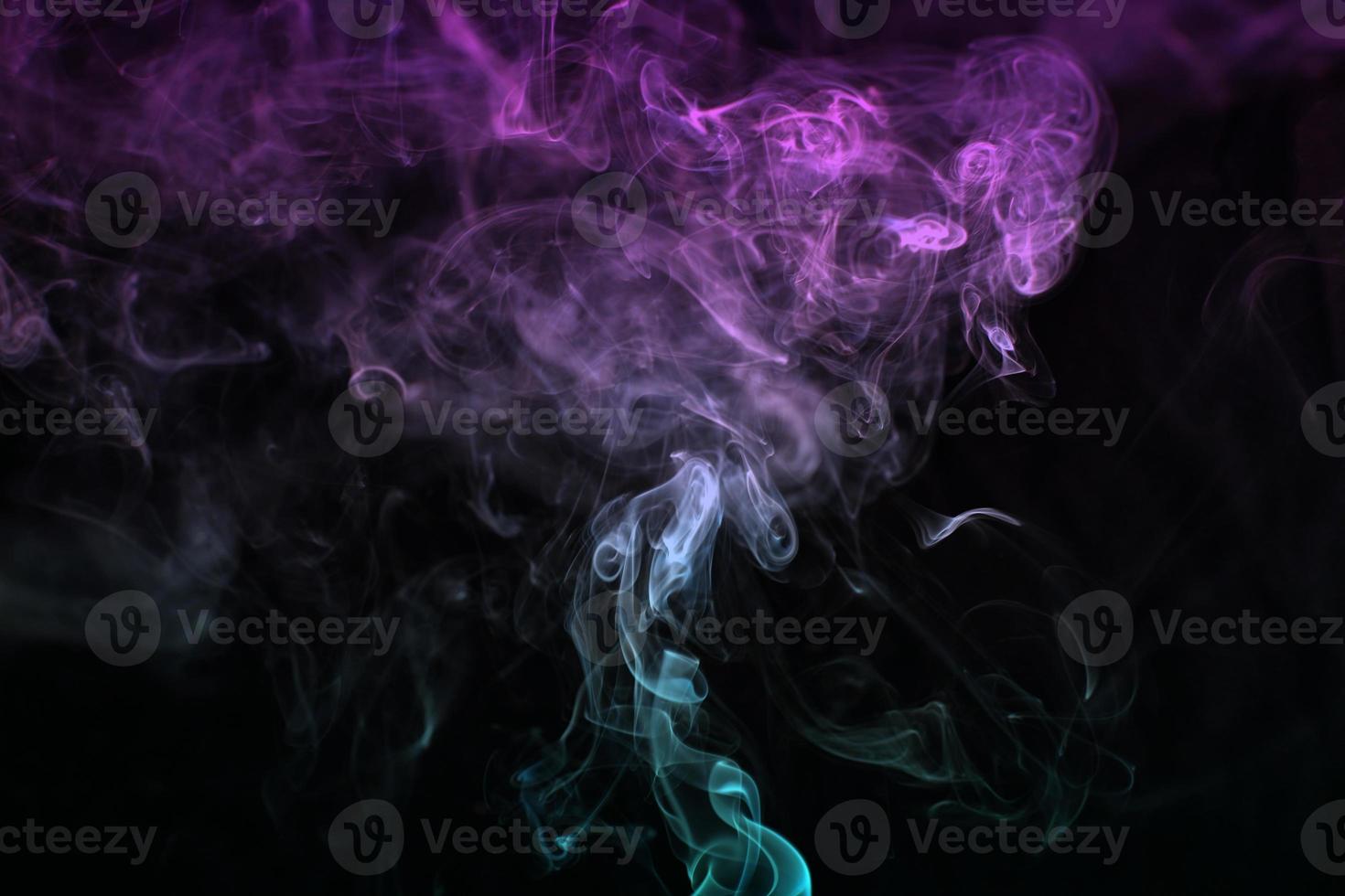 Multicolored smoke for aromatherapy relaxation on black background, beautiful swirled puffs of smoke photo