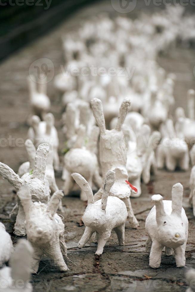 estatuas de conejo blanco hechas de yeso en una exposición de arte al aire libre, graciosas liebres blancas en la calle foto