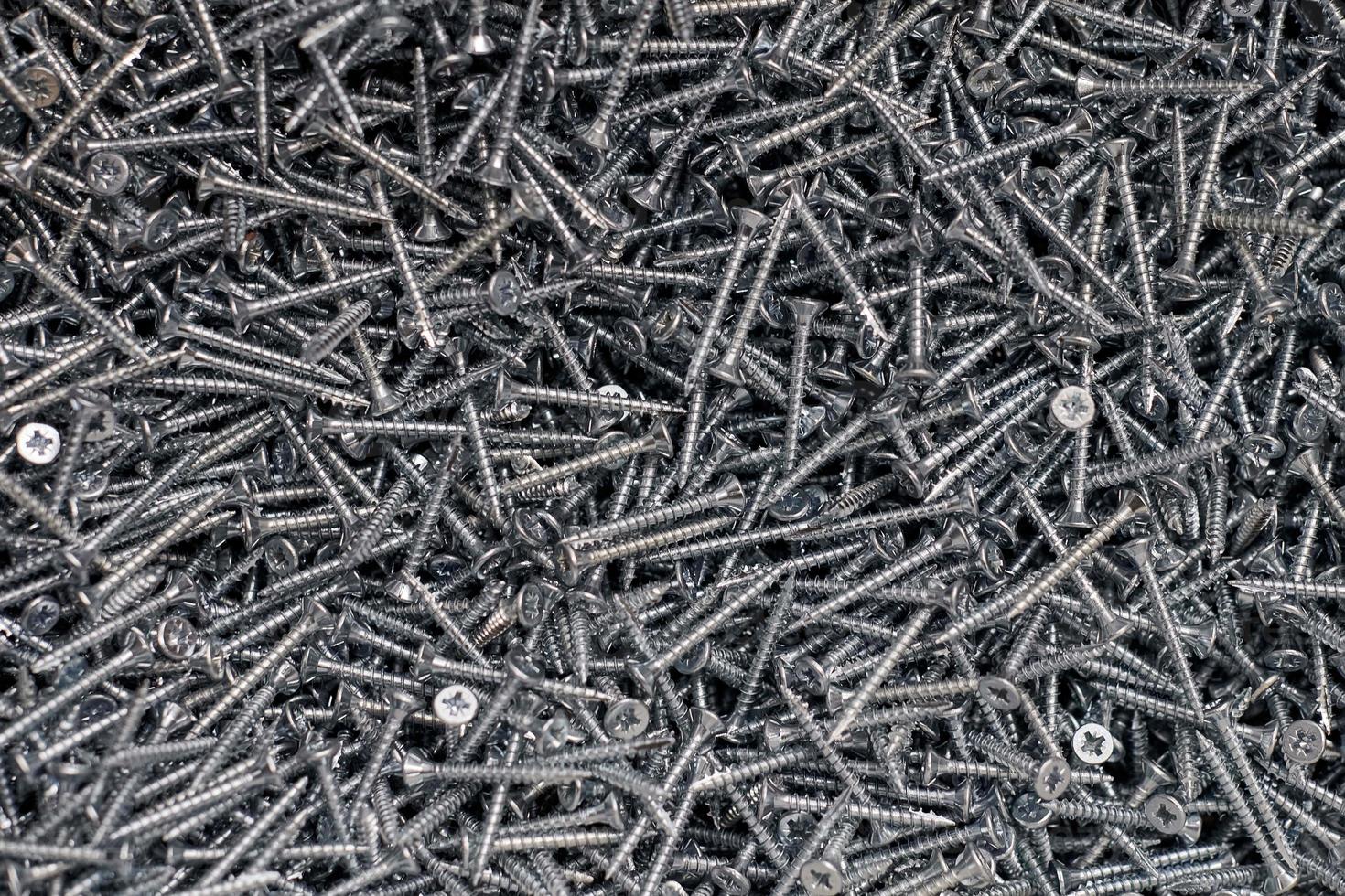 Bunch of galvanized stainless screws with flat countersink head, hardware background, silver screws photo