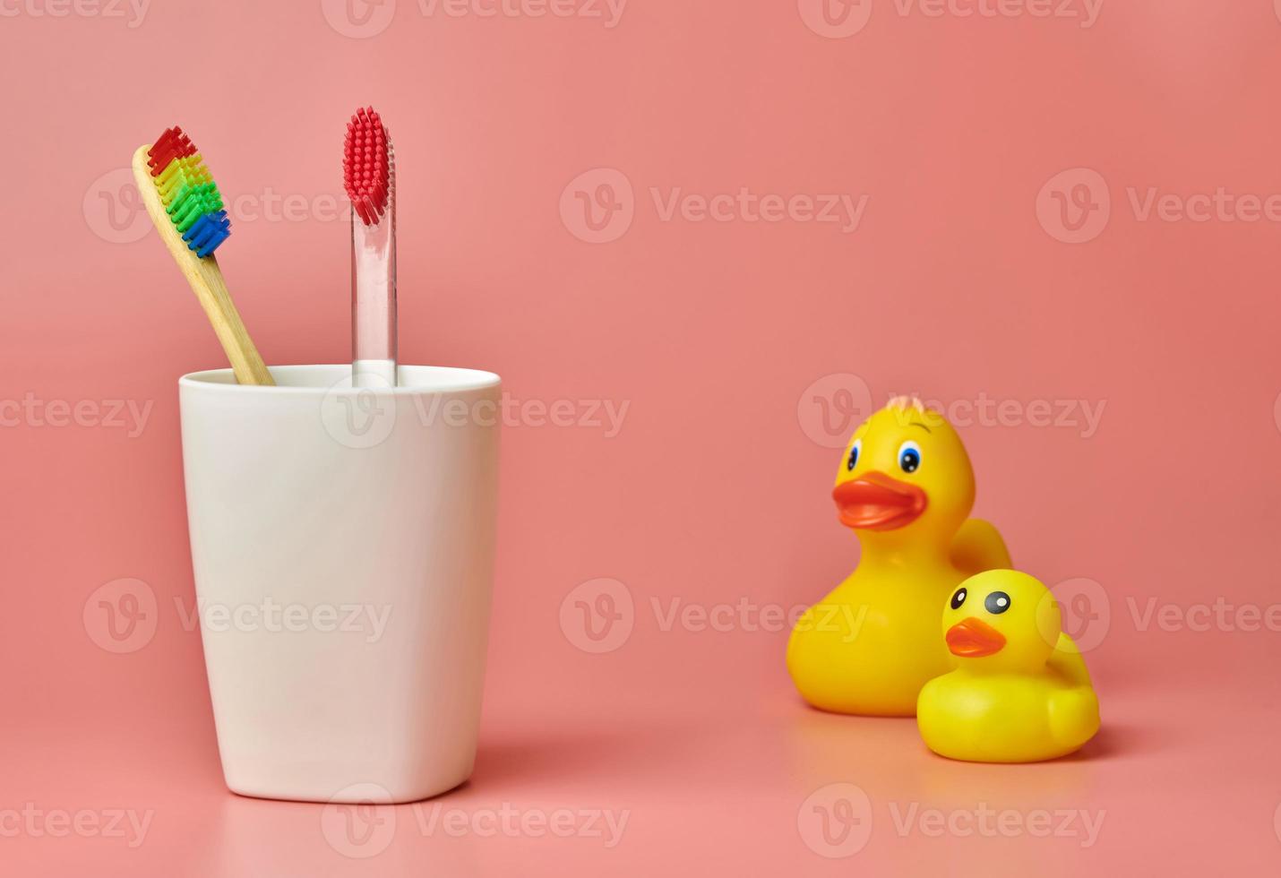 Two toothbrush and duck toy, copy space. Personal care tool for protect oral cavity, remove plaque and tartar. photo