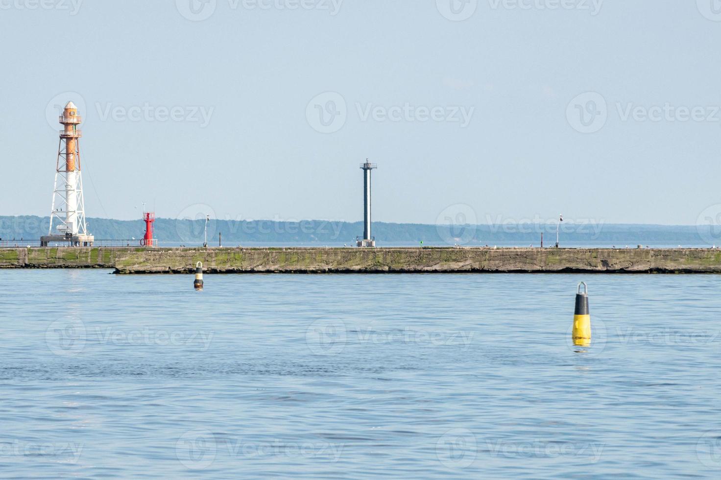 Jetty with towers and buoys. Beautiful seascape, copy space. Breakwater for protect ships at shipyard from waves photo