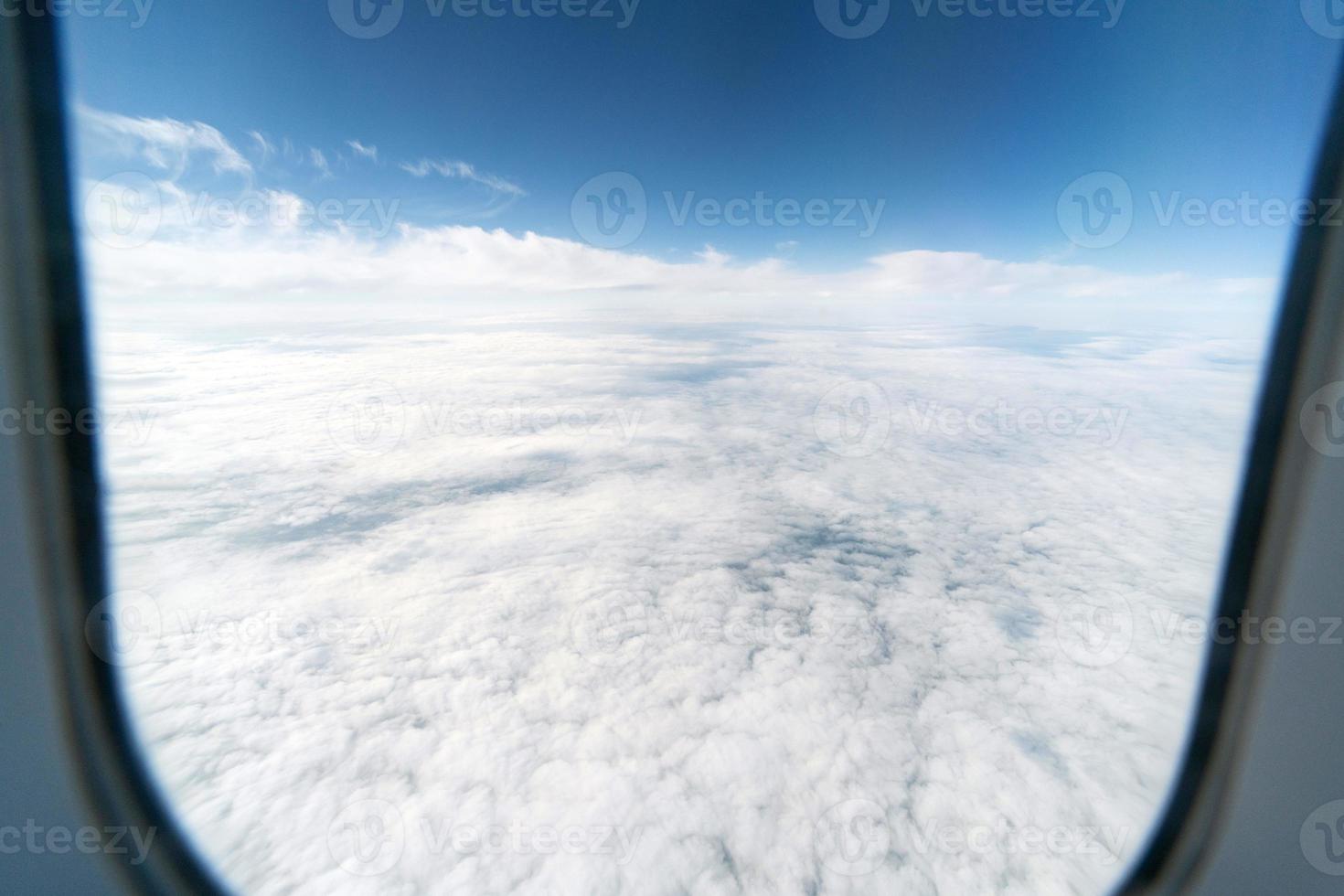 Airplane window view to cloudy sky. Beautiful landscape from aircraft cabin. Flying without incident and turbulence. photo