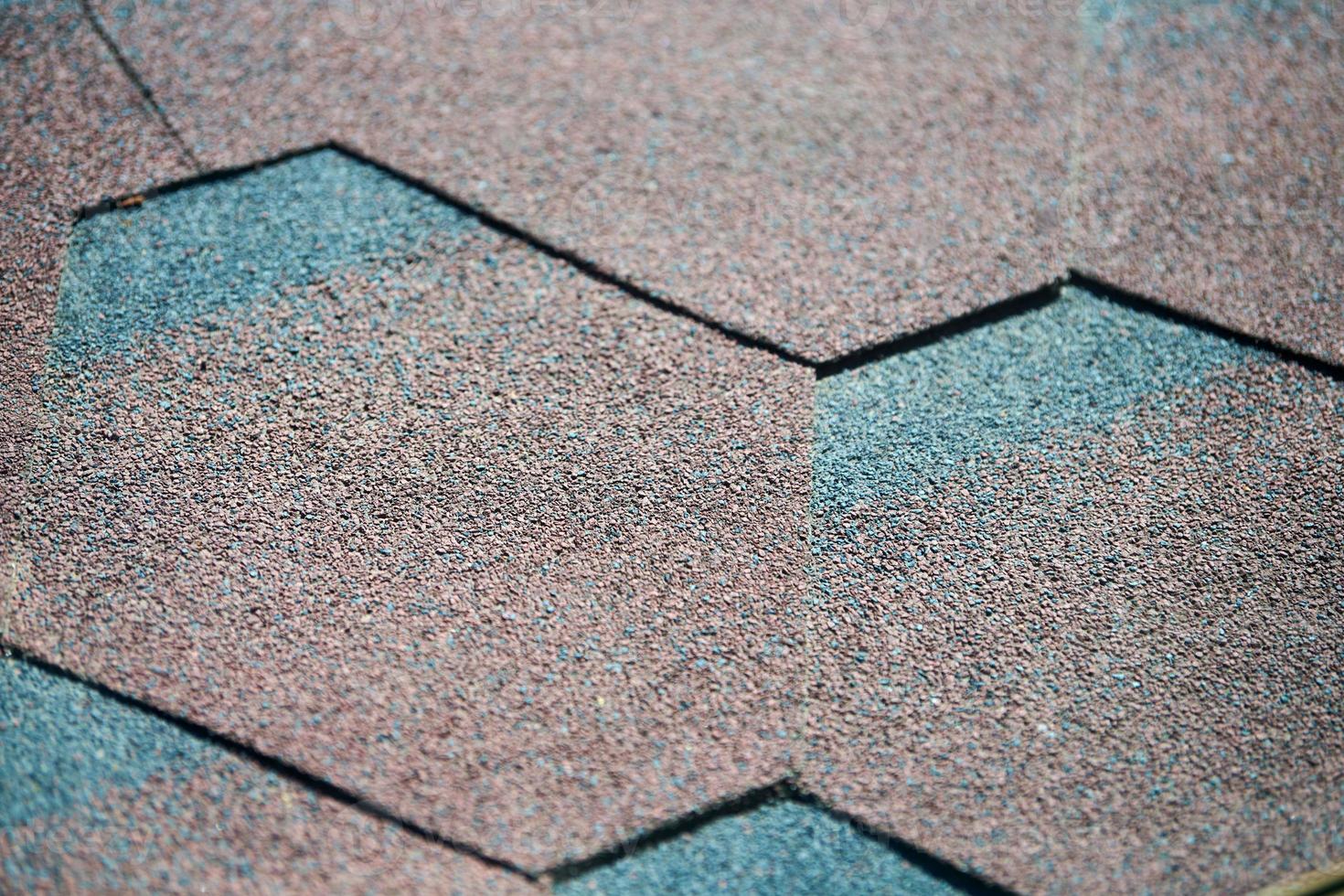Modern roof shingles tiles, close up. Soft asphalt roof cover. New roofing construction. Easy roofing repair. photo
