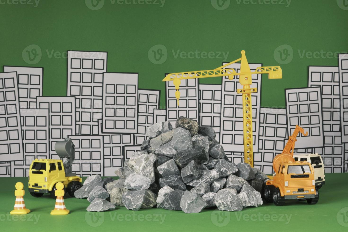 Models simulator on green background, construction vehicles toys, trucks, backhoes, and cranes work at site, transport resource materials, rock, and mortar, real estate business, and city development. photo