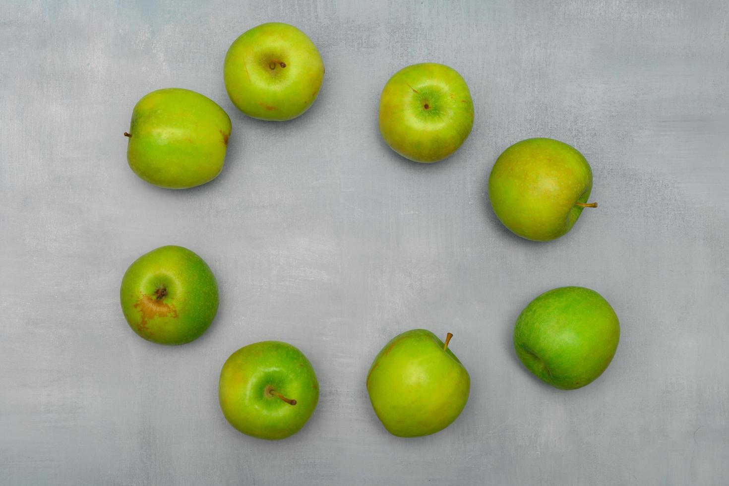 Fresh ripe green apples on a grey rustic table photo