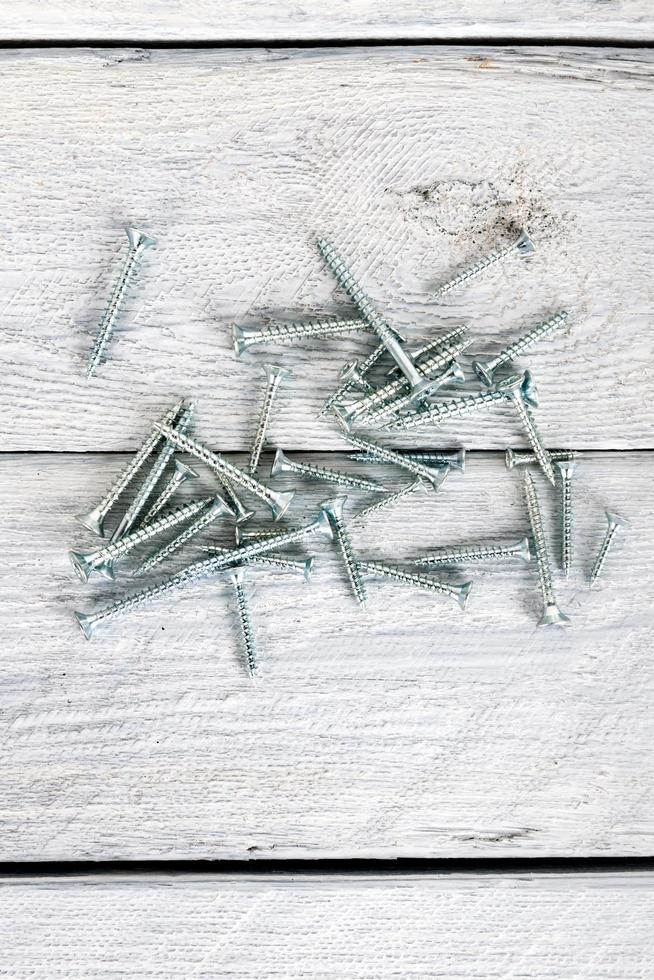 Screws on wooden background photo