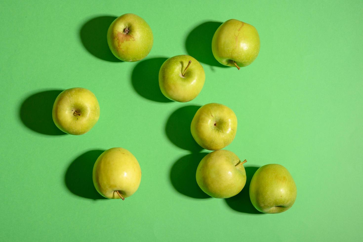 Fresh ripe green apples on a green background photo