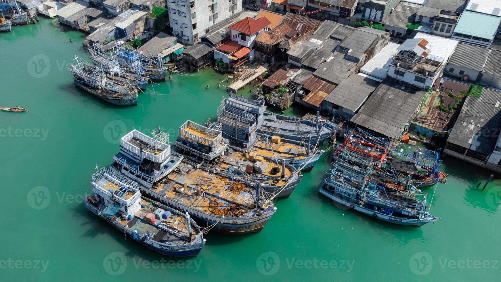 vista aérea del muelle de pescadores que tiene muchos barcos anclados para transportar mariscos y suministros en la isla de songkhla, tailandia foto