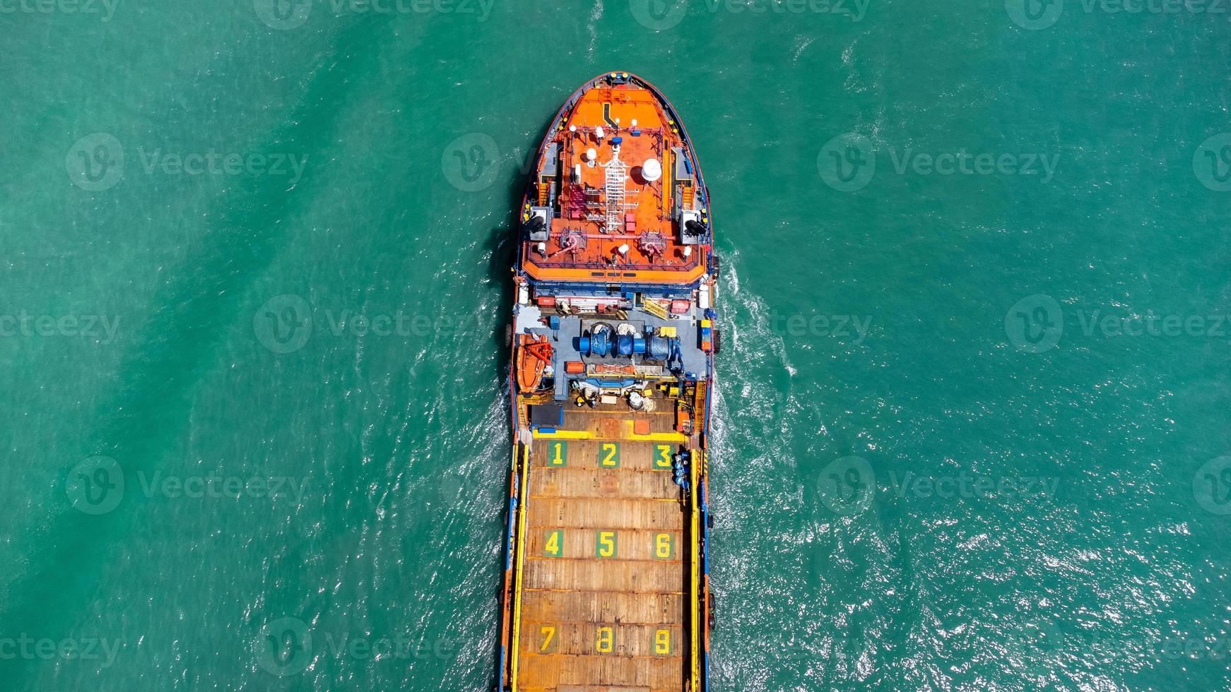 vista aérea en la parte superior del buque de carga que transporta un contenedor y se ejecuta para exportar el puerto del patio de carga al océano personalizado internacional. concepto de transporte de tecnología, despacho de aduanas, banner de seminario web. foto