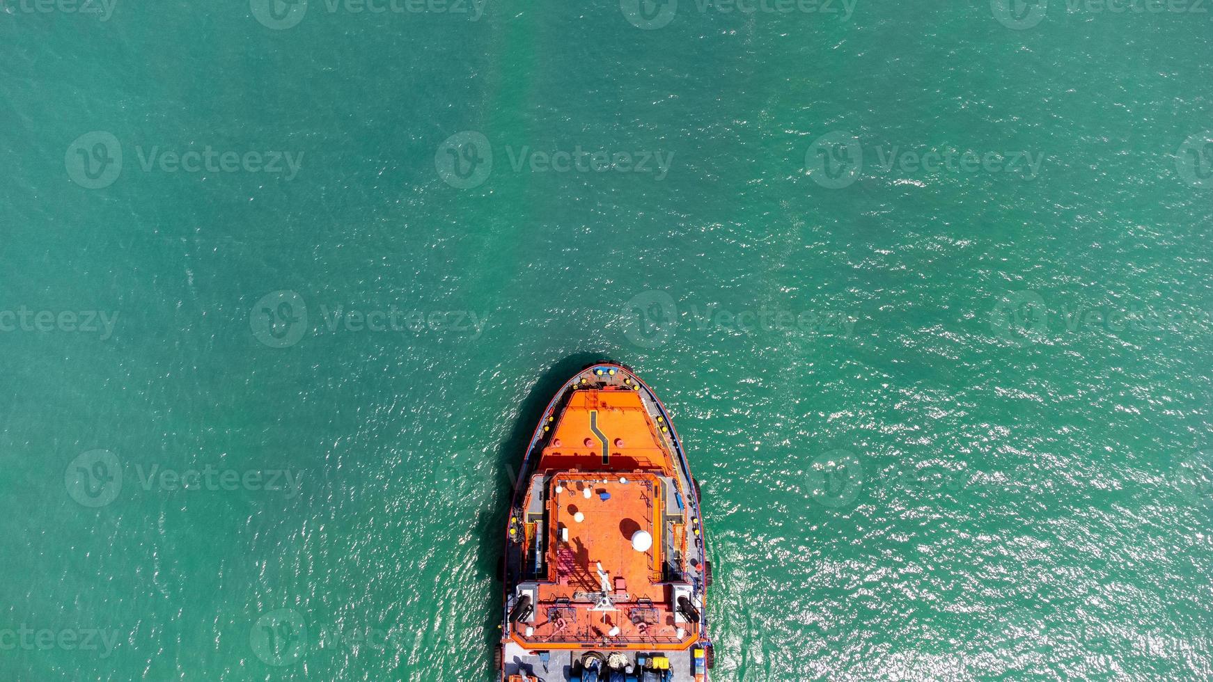 vista aérea en la parte superior del buque de carga que transporta un contenedor y se ejecuta para exportar el puerto del patio de carga al océano personalizado internacional. concepto de transporte de tecnología, despacho de aduanas, banner de seminario web. foto