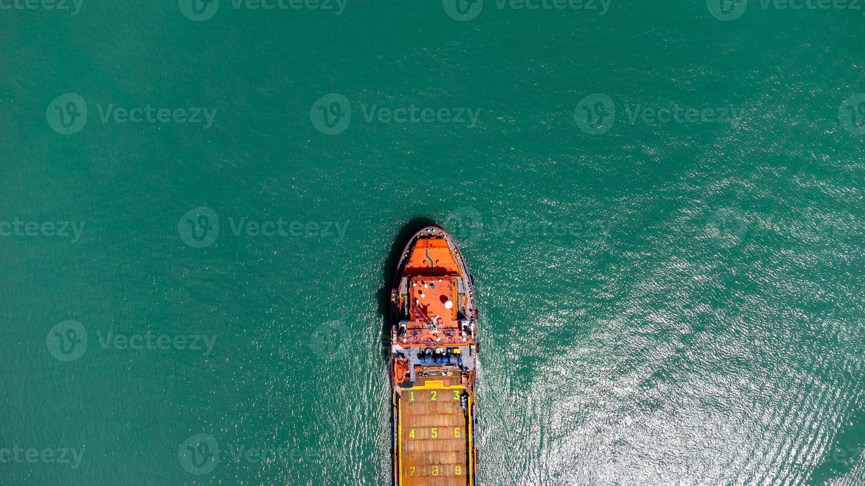 vista aérea en la parte superior del buque de carga que transporta un contenedor y se ejecuta para exportar el puerto del patio de carga al océano personalizado internacional. concepto de transporte de tecnología, despacho de aduanas, banner de seminario web. foto