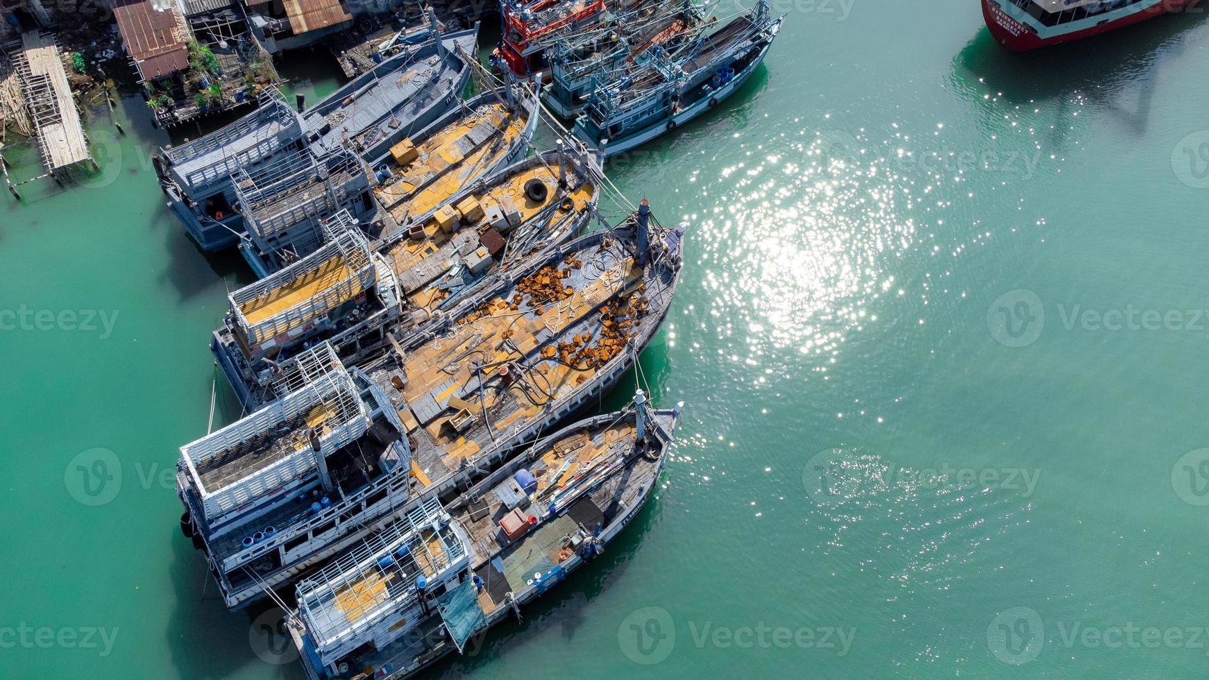 vista aérea del muelle de pescadores que tiene muchos barcos anclados para transportar mariscos y suministros en la isla de songkhla, tailandia foto