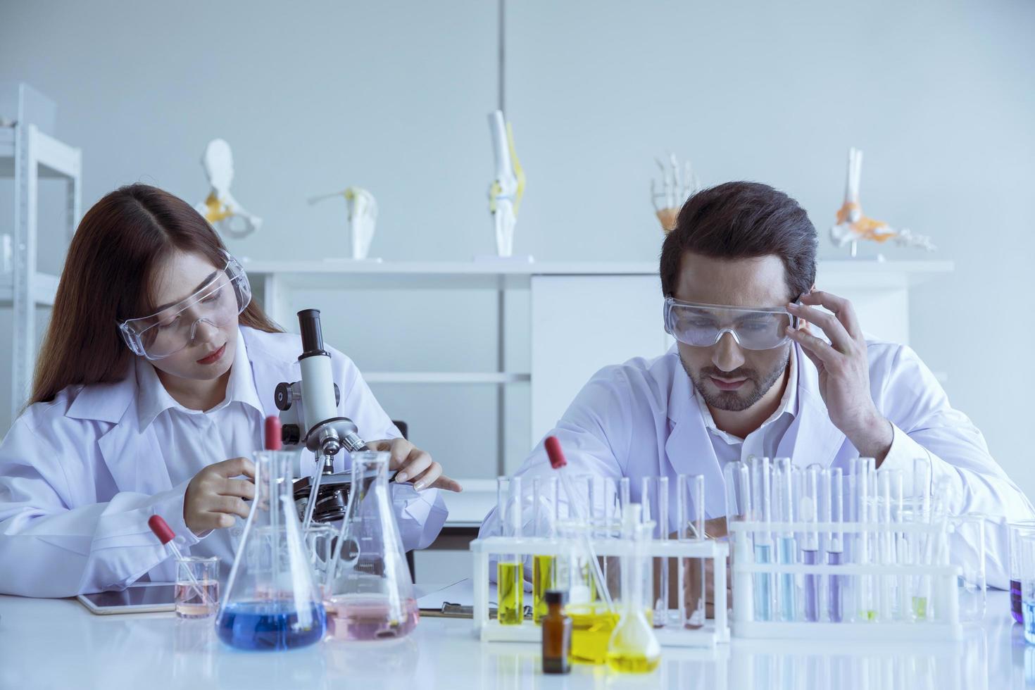 Attractive scientist medical worker with sample test COVID-19 or coronavirus tube at laboratory , doing a analysis in a laboratory doing research to create a vaccine and development photo