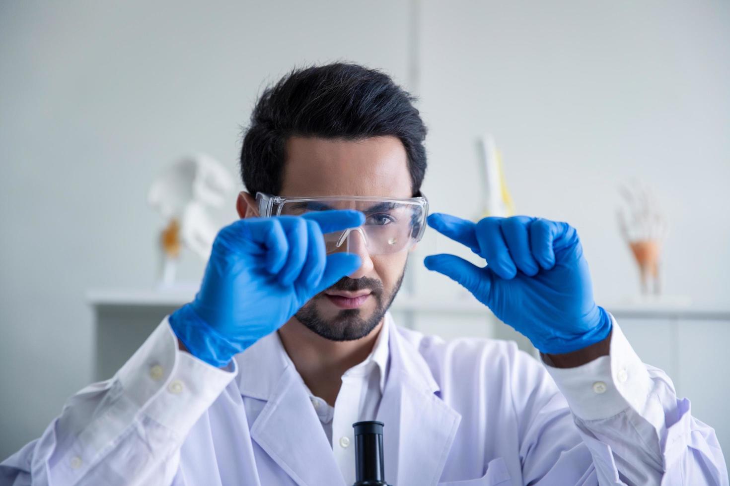 Attractive scientist medical worker with sample test COVID-19 or coronavirus tube at laboratory , doing a analysis in a laboratory doing research to create a vaccine and development photo