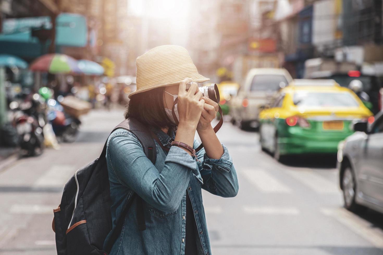 mujeres asiáticas con mascarilla quirúrgica viajera con viaje en cámara de retrato de estilo de vida, concepto de verano al aire libre foto