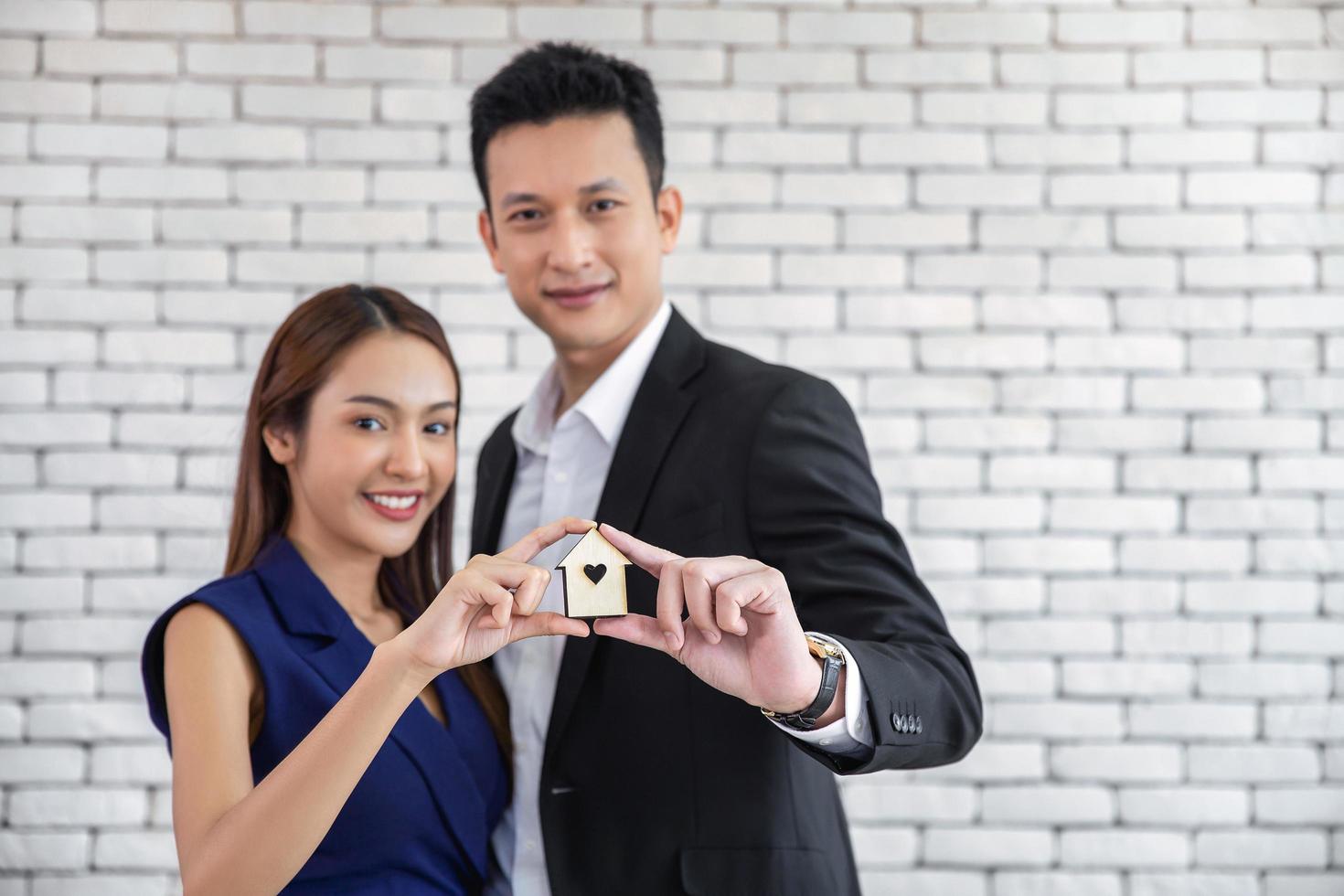 Happy young loving couple talking to their real estate agent with smile looking at house , Planning for the future of the family concept photo