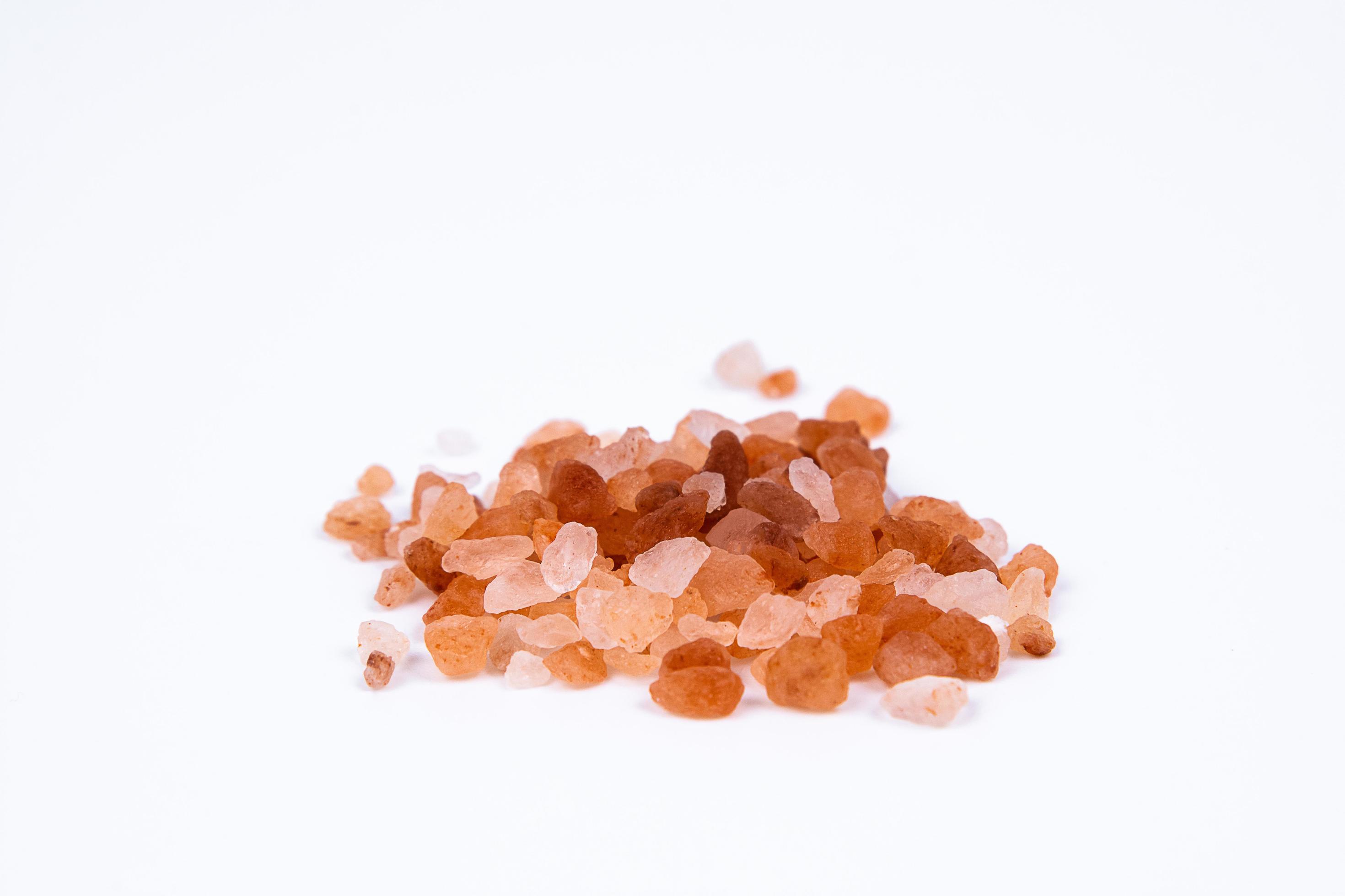 Himalayan pink rock salt on white background. Background of salt
