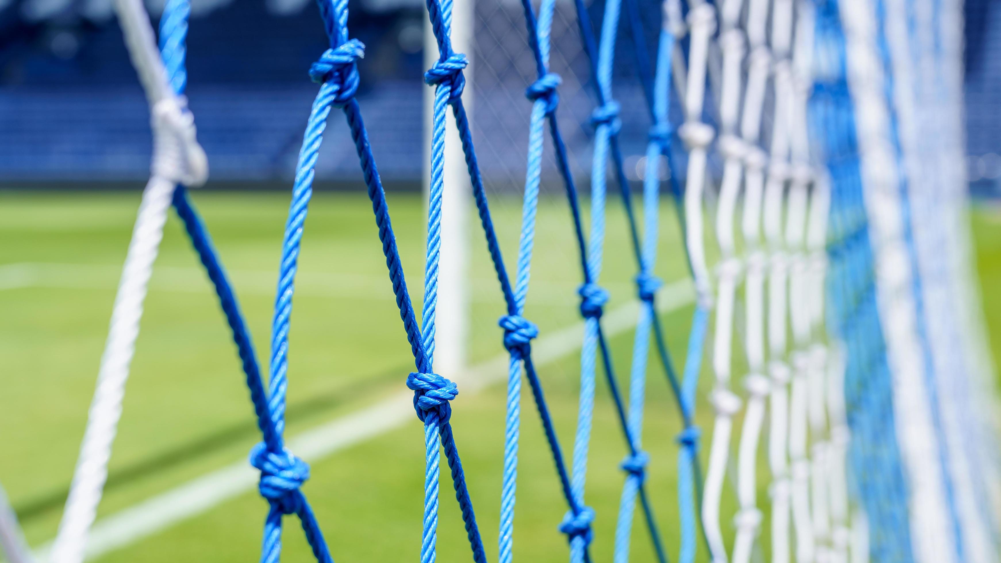 Behind the ropes of the outdoor soccer field goal net, football goal