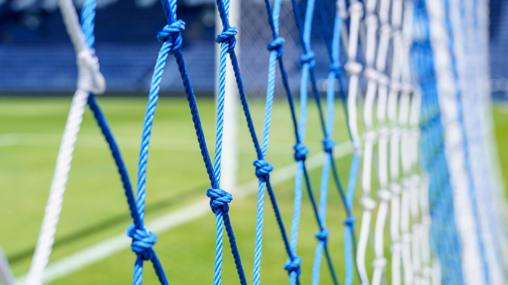 Behind the ropes of the outdoor soccer field goal net, football goal background photo