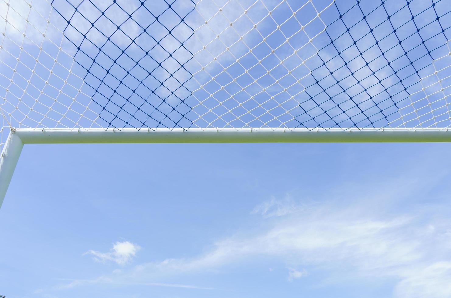Behind the ropes of the outdoor soccer field goal net, the football goal background photo