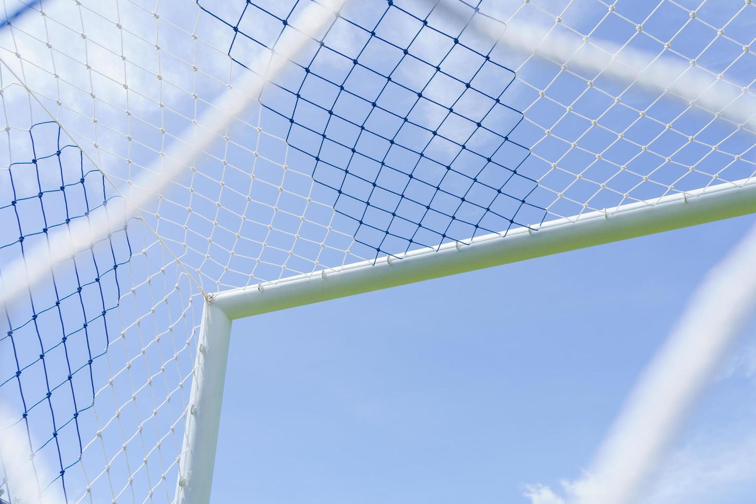 Behind the ropes of the outdoor soccer field goal net, the football goal background photo