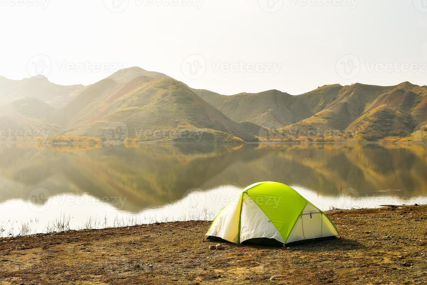 Mravaltskaro reservoir in autumn with tent and white desert canyons in background. Georgia travel destination in autumn photo