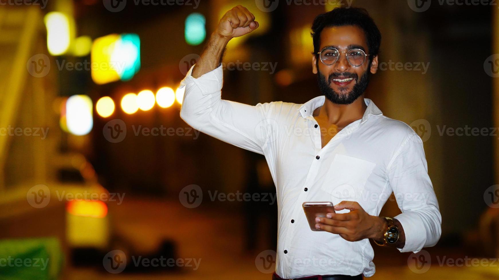 niño indio usando el móvil con emoción foto