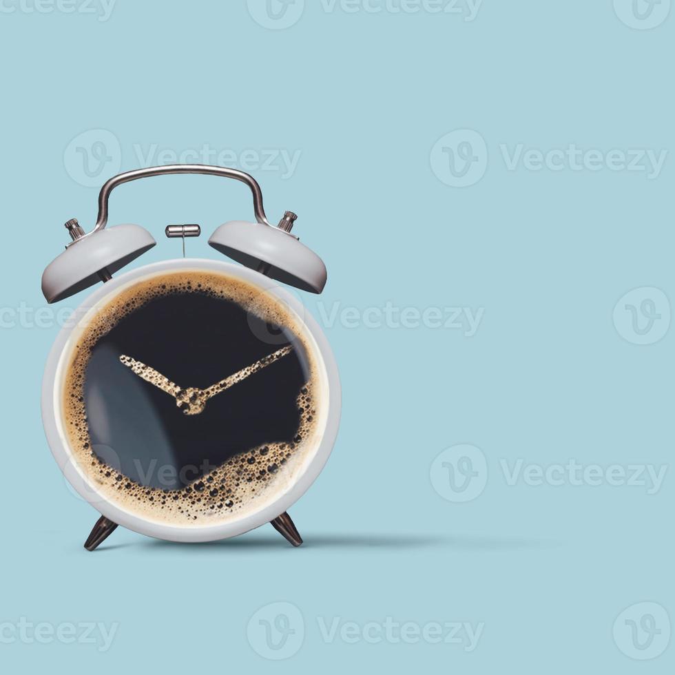 Alarm clock and coffee concept isolated on pastel blue background. Alarm clock as coffee cup over blue background. Creative minimal concept. Wake up alarm coffee concept. photo