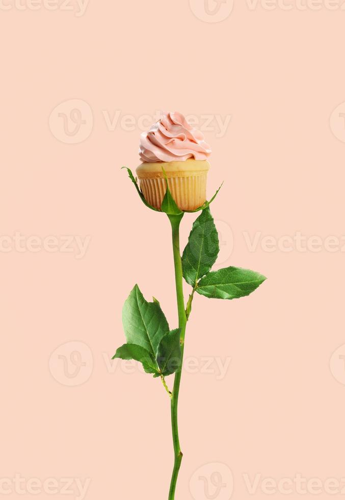 cupcake de cumpleaños como una hermosa rosa solitaria. concepto de verano. fondo rosa pastel. tarjeta de felicitación de cumpleaños. foto
