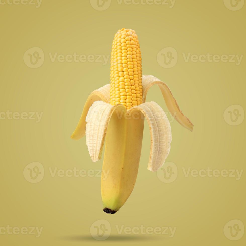 Cob of corn in the peel of banana on yellow background. Fruit concept. Food creative concept. Photo manipulation with banana. Art concept.