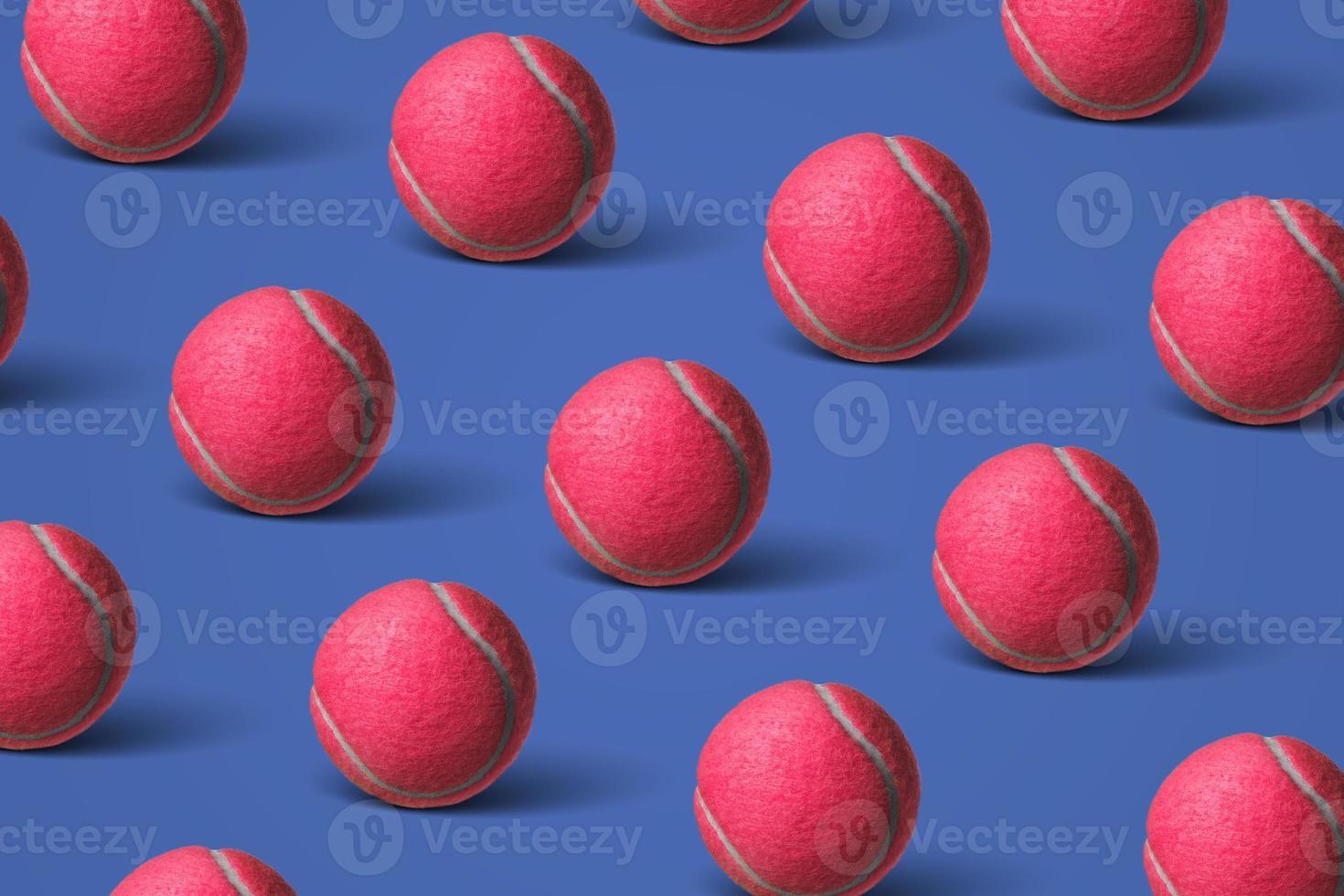 Pattern pink tennis balls on a dark blue background. Flat lay. photo