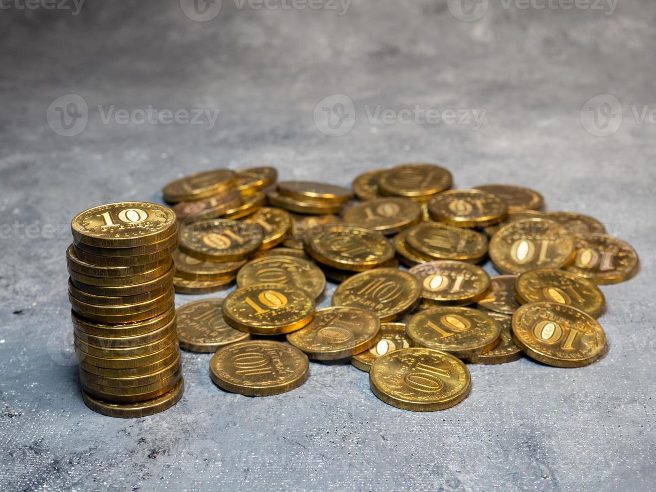 Pyramid of coins on a gray background. A pile of coins. photo