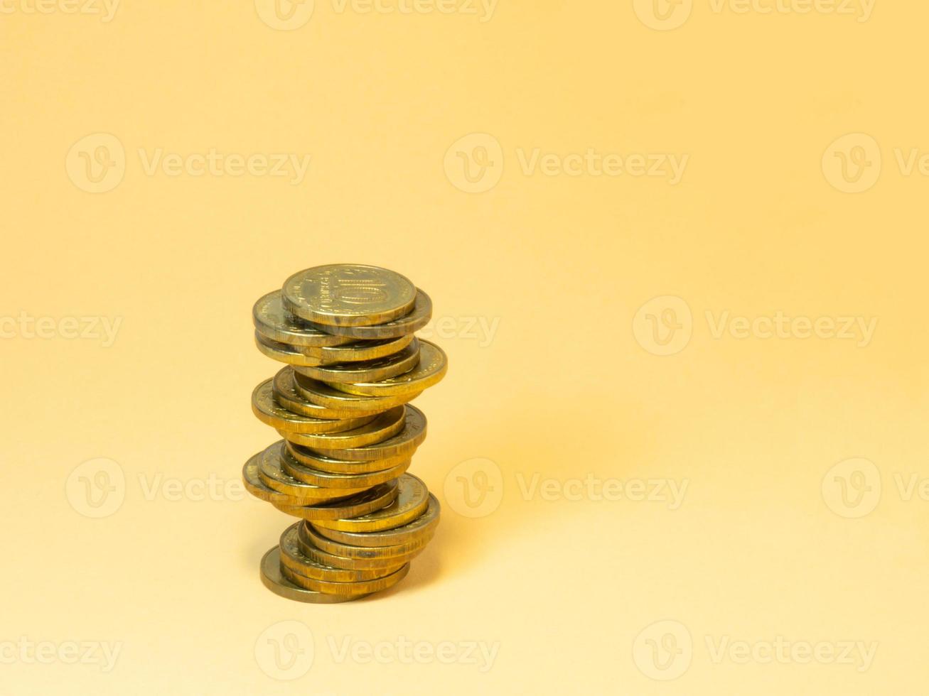 A turret made of coins. Money on yellow background photo