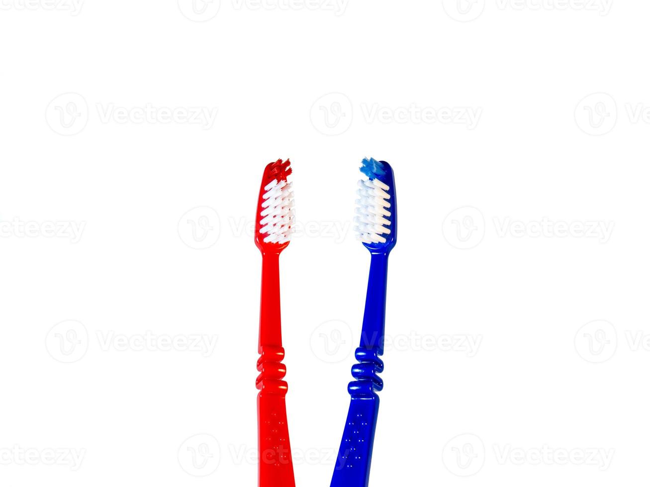 Two toothbrushes on a white background. Blue and red toothbrushes photo