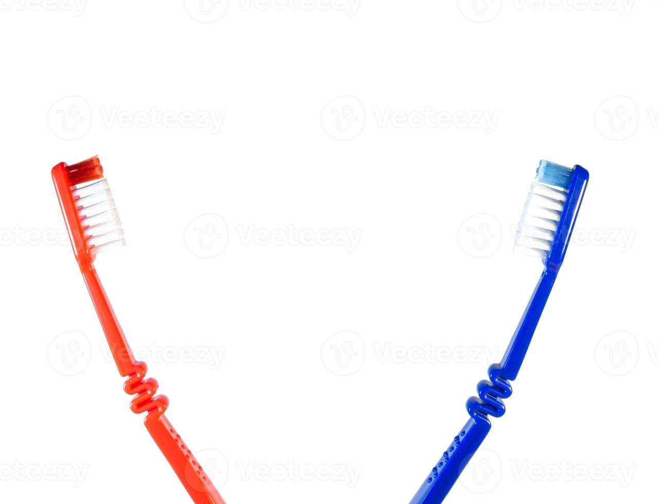 Two toothbrushes on a white background. Blue and red toothbrushes photo