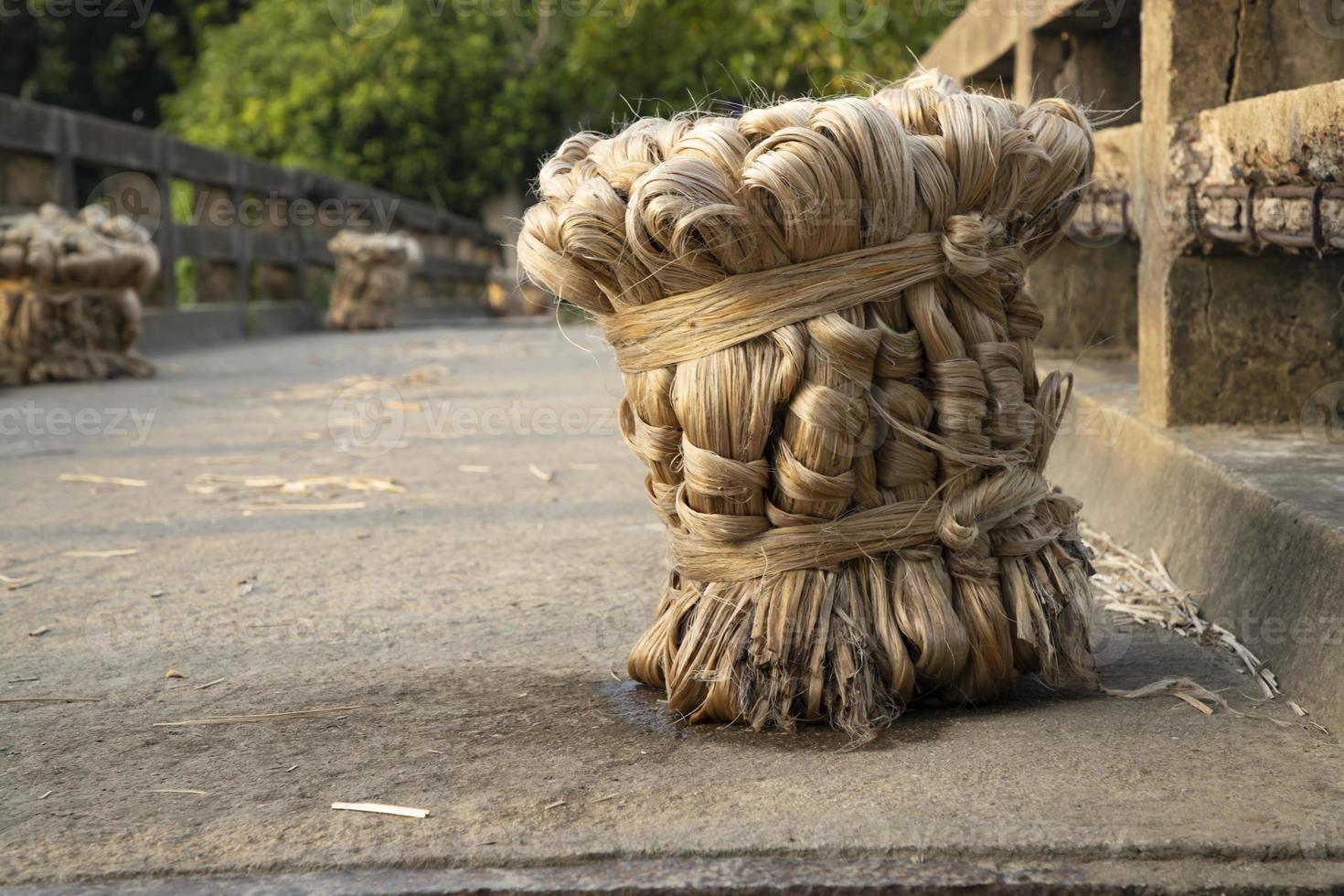 A thick brown  bundle of  raw jute has on the ground photo