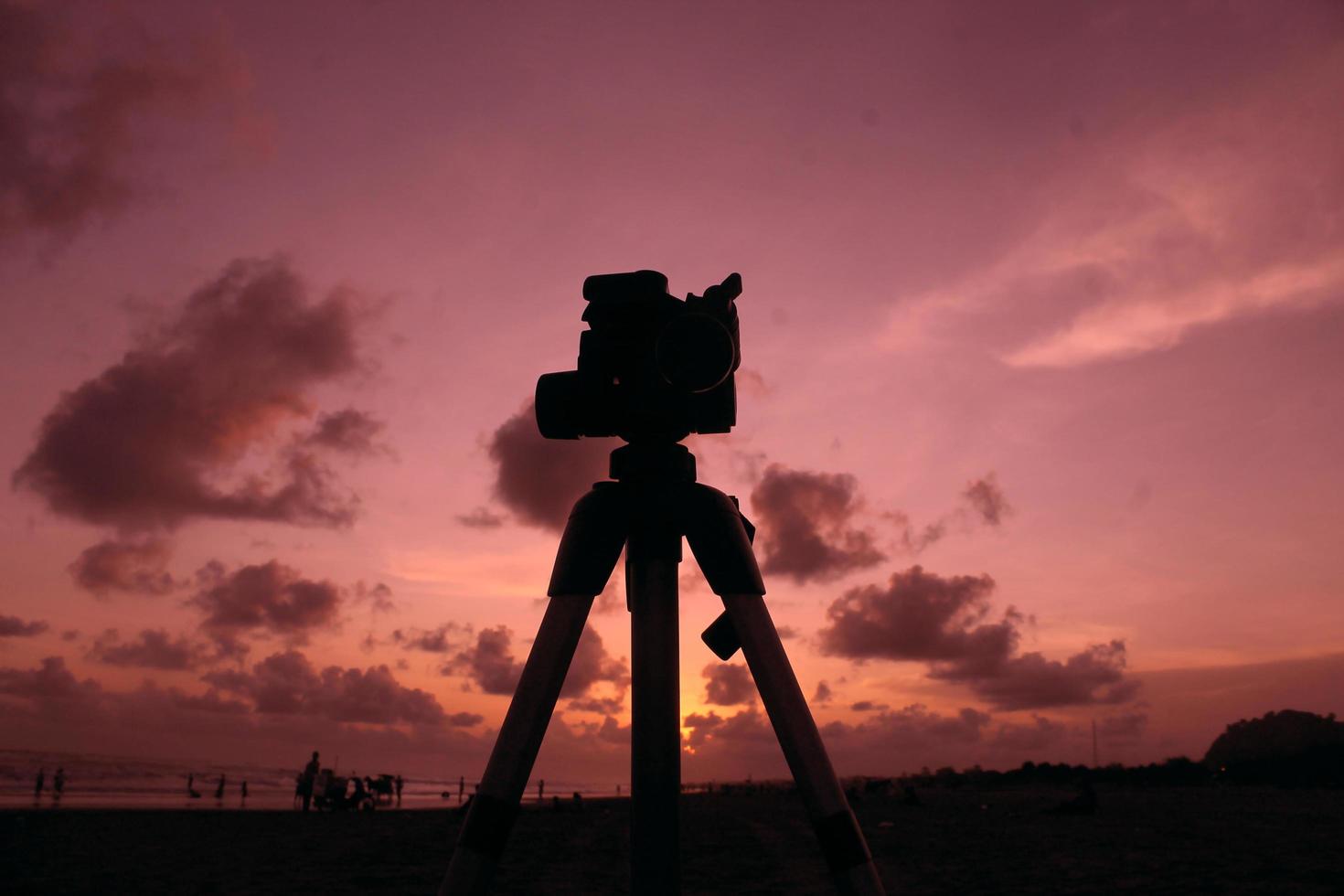 silhouette of camera with tripod in sunset photo