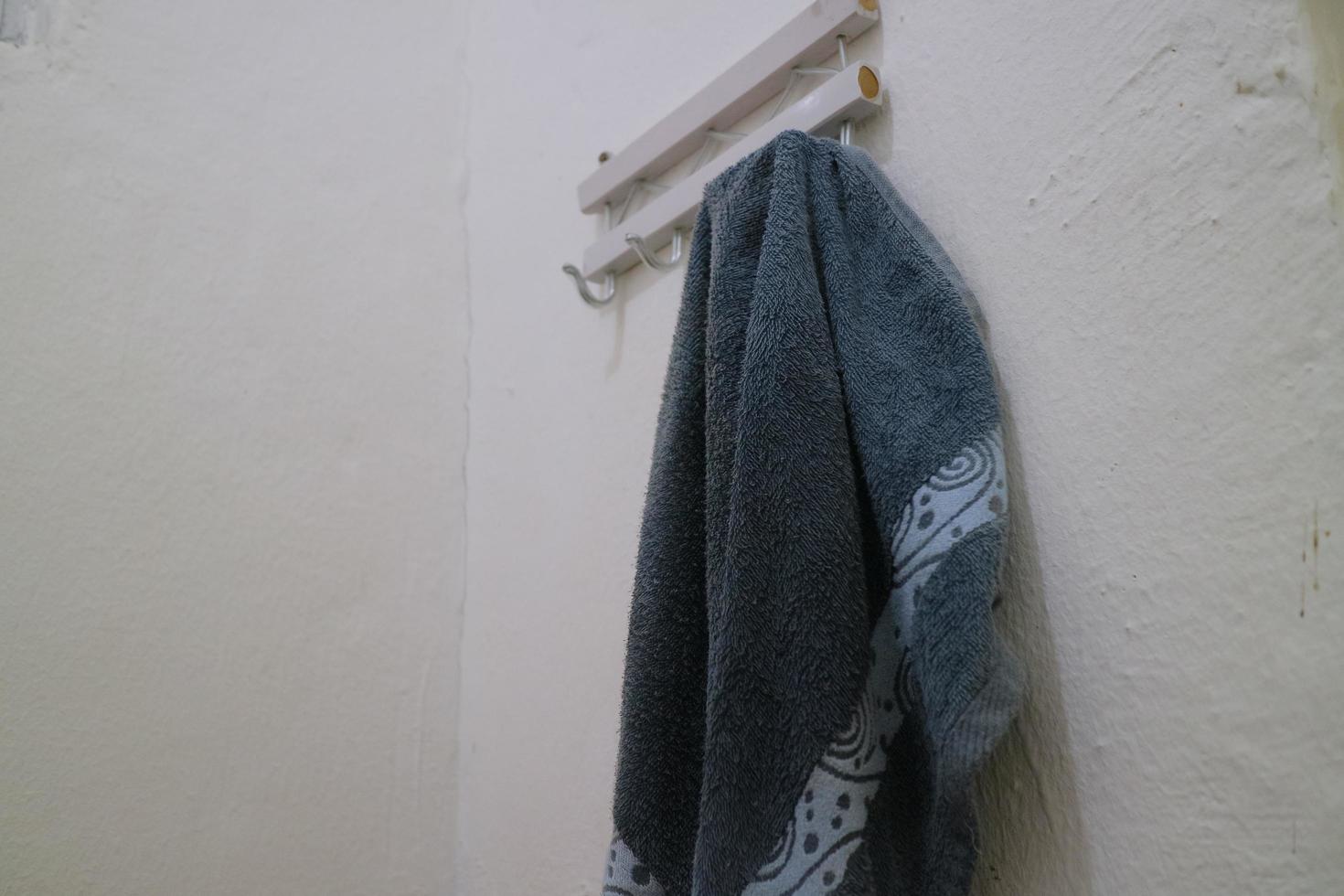 dark blue wet towel hung on the bathroom wall photo