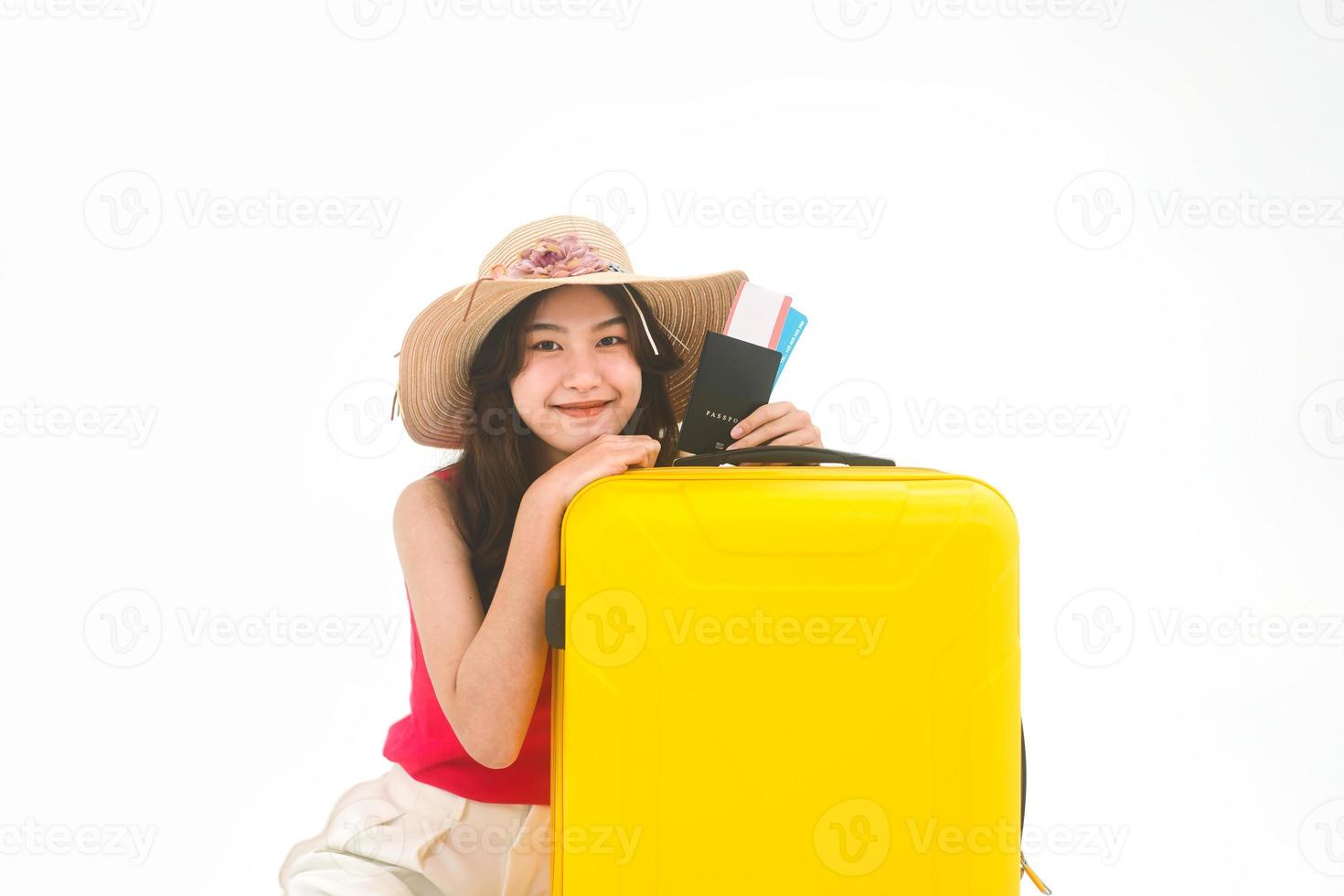 retrato de una joven adulta del sudeste asiático con equipaje de viaje amarillo y pasaporte sobre fondo blanco aislado foto