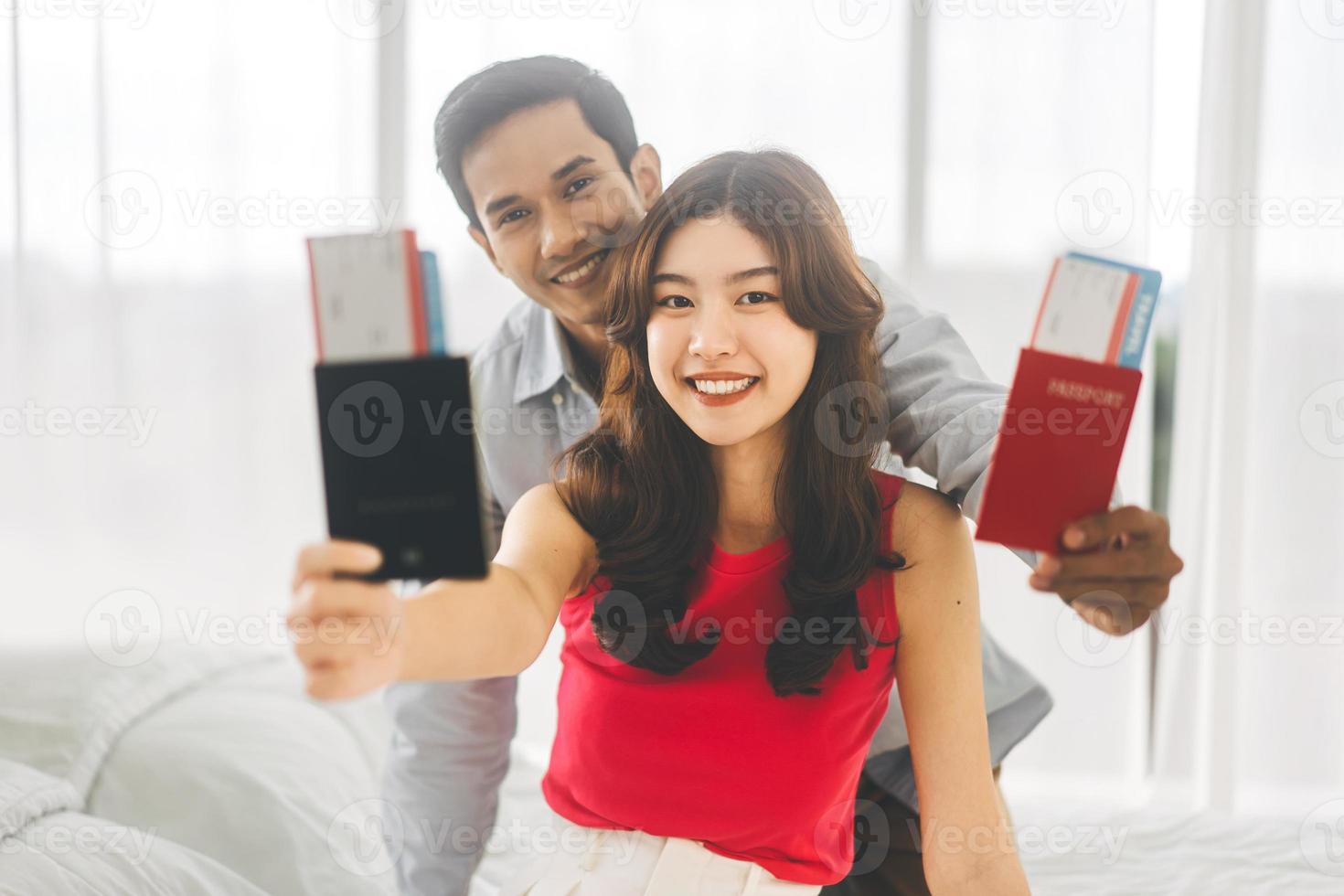 Portrait of asian couple man and woman showing passport and airplane ticket for travel photo