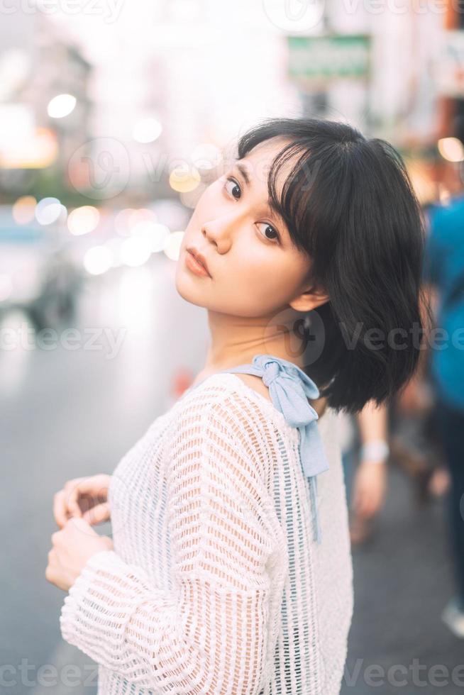 retrato de una joven asiática adulta con moda japonesa al estilo de los años 80 en la ciudad al aire libre foto