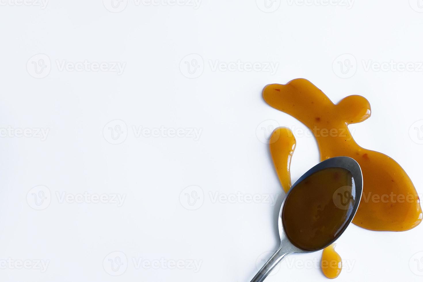 the drops of homemade sauce and a spoon on a white background photo